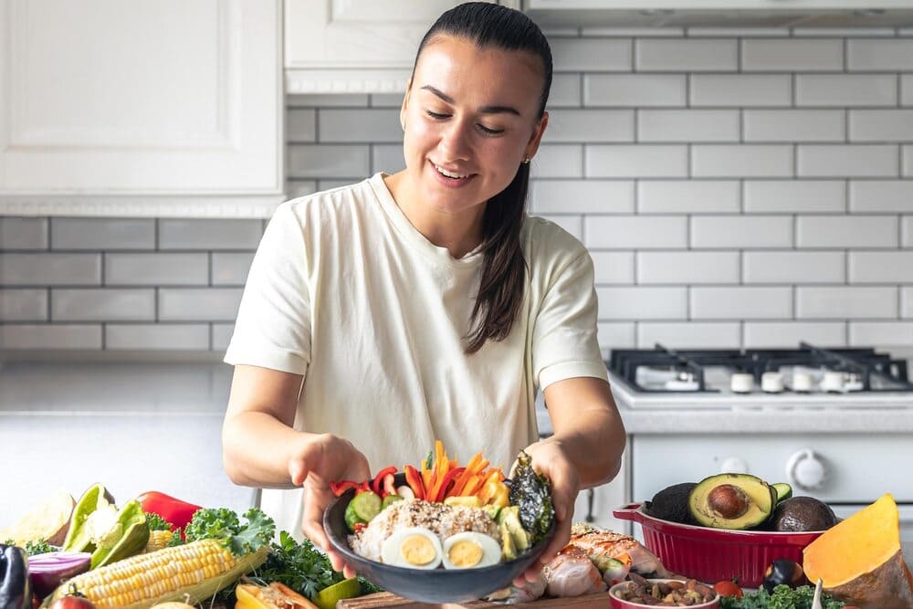 a-young-woman-with-a-plate-of-vegetables-rice-and-eggs-in-the-kitchen
