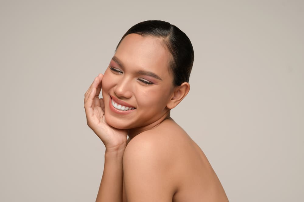 beautiful-asian-woman-touches-cheek-smiles-for-having-followed-the-tips