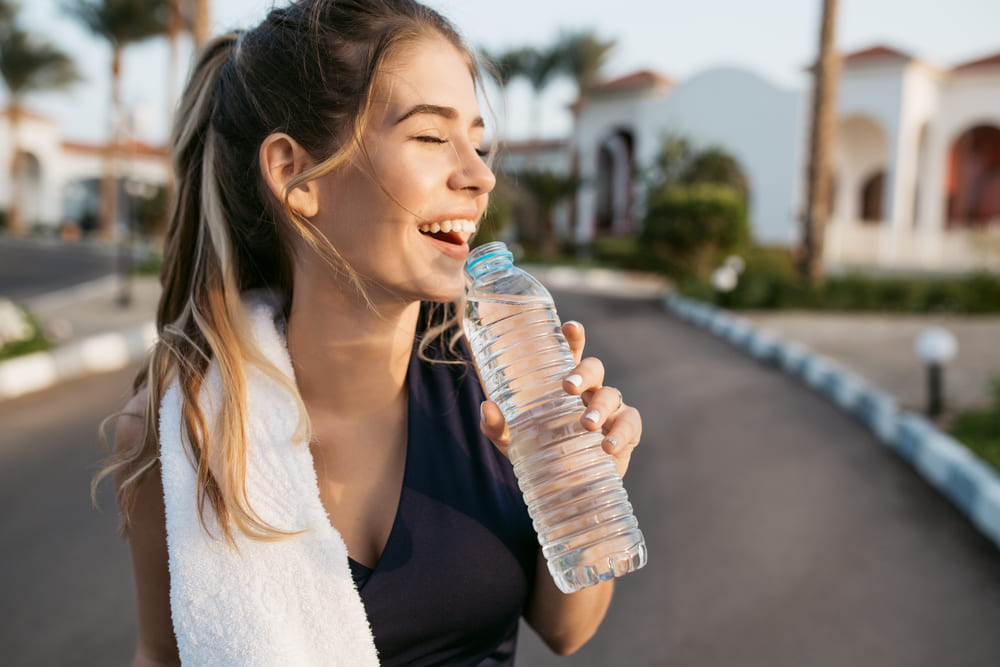 closeup-portrait-excited-happy-young-woman-smiling-with-closed-eyes-sun-with-bottle-water-attractive-sportswoman-enjoying-summer-training-outwork-happiness