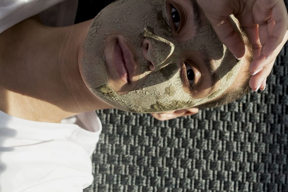 woman-looking-camera-with-facial-mud-treatment