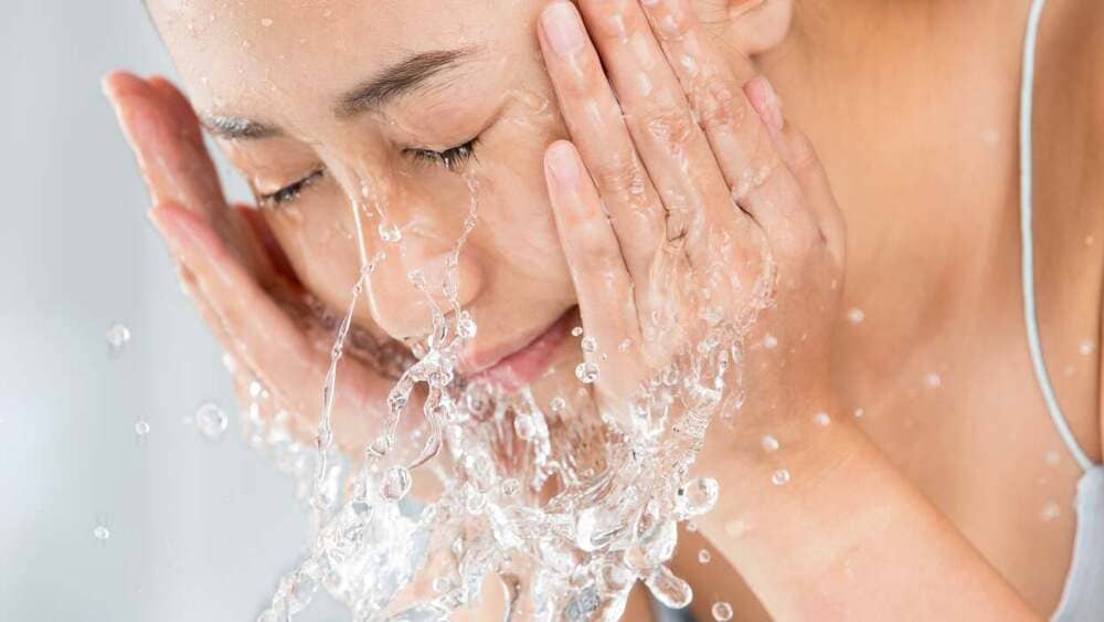 woman-washing-her-face-with-water