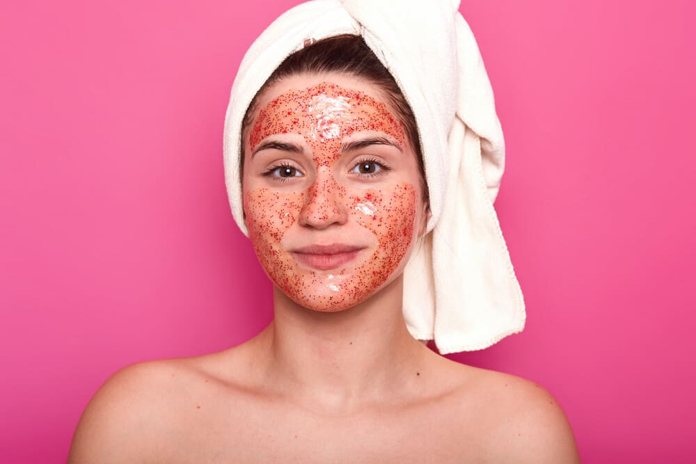 young-attractive-woman-with-white-towel-her-head-has-naked-body-smilling-isolated-pink-wall-studio-looks-directly-camera-having-with-Exfoliation-product-on-your-face