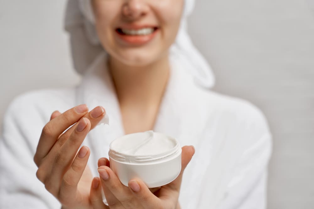 young-woman-close-up-holding-moisturizer-demonstrates